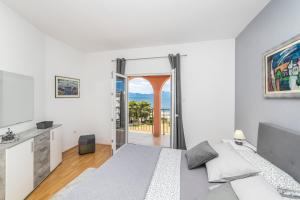 Schlafzimmer mit einem Bett und einer Tür zu einem Balkon in der Unterkunft APARTMANI LILE in Gradac