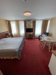 Una habitación de hotel con una cama, una mesa y sillas. en JūRa 28, en Klaipėda