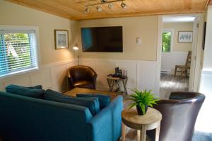 a living room with a blue couch and a tv at Wild Coast Wilderness Resort in Port Renfrew