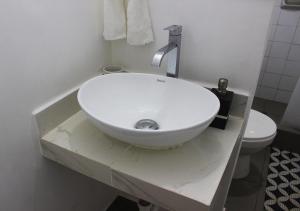 La salle de bains est pourvue d'un lavabo blanc et de toilettes. dans l'établissement Acogedor departamento en Barranco, à Lima