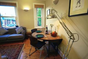 uma sala de estar com uma mesa e um candeeiro em Boscobel Apartments Up em Winchester