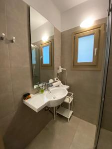 a bathroom with a sink and a mirror and a shower at Lithos by Spyros & Flora in Agios Ioannis Mykonos