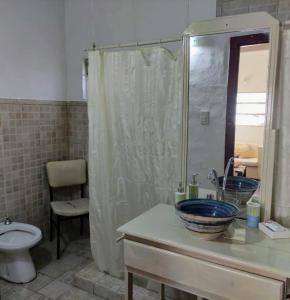 Un baño con lavabo, inodoro y ducha. en Abbá Departamentos, en Mina Clavero