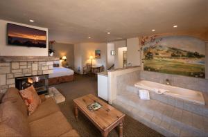 ein Wohnzimmer mit einem Kamin, einem Bett und einer Badewanne in der Unterkunft Horizon Inn & Ocean View Lodge in Carmel