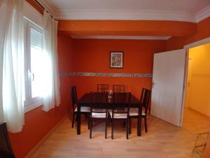 a dining room with a black table and chairs at A casa de Xues in Pontevedra