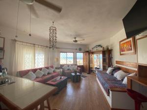 een woonkamer met een bank en een tafel bij Casa Náutica Beach Guesthouse for Kiters & Surfers in Los Órganos