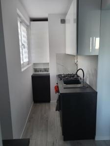 a kitchen with a sink and a stove in it at Apartament na Skwerku in Gdynia