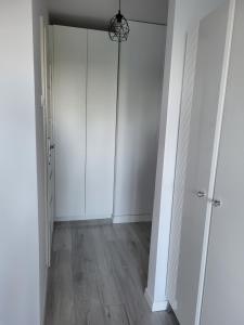 un pasillo vacío con paredes blancas y una puerta en Apartament na Skwerku, en Gdynia