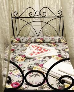 a bed with a floral bedspread and towels on it at Le Coccole Del Trasimeno in Tuoro sul Trasimeno