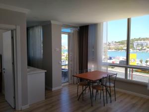 a dining room with a table and chairs and a large window at VENÜS PARK APART SUİTES in Çeşme