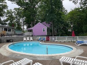 a swimming pool with chairs and a purple house at New Hope Lodge in New Hope