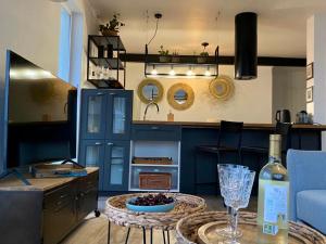 a kitchen with blue cabinets and a table with a wine glass at SunPola Penthouse in Santa Pola