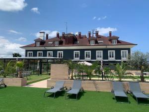 un groupe de chaises assises sur l'herbe devant une maison dans l'établissement 1907 VILLA GIJON, à Gijón