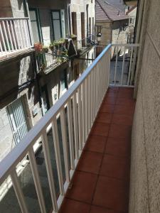 a balcony of a house with a white railing at Apartamentos A Casa da Herba in Redondela
