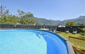 a blue swimming pool with mountains in the background at Nice Home In Camaiore With Kitchen in Camaiore