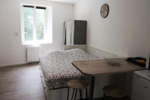 - une cuisine avec un lit, une table et des tabourets dans l'établissement Charmant studio, à Charleville-Mézières