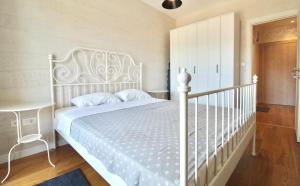 sypialnia z białym łóżkiem i białym łóżeczkiem dziecięcym w obiekcie Albatros Apartments w Barze