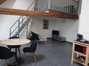 ein Wohnzimmer mit einem Tisch, Stühlen und einer Treppe in der Unterkunft Beaugency-3 sur la route des châteaux in Beaugency