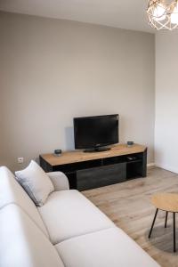 a living room with a white couch and a television at Sunny House in Čapljina