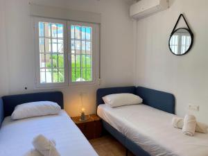 dwa łóżka w pokoju z dwoma oknami w obiekcie Azahara En Suite Casasol w mieście Nerja