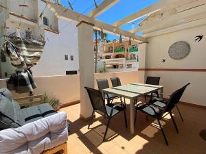 jadalnia ze stołem i krzesłami na patio w obiekcie Azahara En Suite Casasol w mieście Nerja