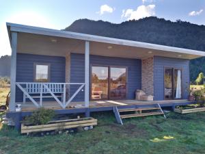 a blue tiny house with a large porch at Cabañas Parque Chaqueihua in Hornopiren