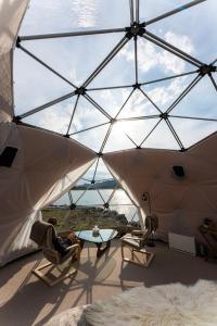 貝圖斯托的住宿－Jotunheimen Arctic Domes，坐在玻璃天花板房间里椅子上的人