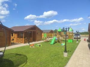 a yard with a playground and a house at Familijny Zakątek domki letniskowe Gąski in Gąski