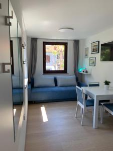 ein Wohnzimmer mit einem blauen Sofa und einem Tisch in der Unterkunft Apartma Manuel in Izola