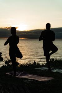 a man and a woman doing yoga by the water at Pipa Villa ByBeck - Praia do Amor - Casa inteira in Pipa +73 photos