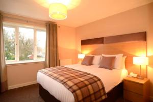a bedroom with a large bed and a window at The Acarsaid - Pitlochry in Pitlochry