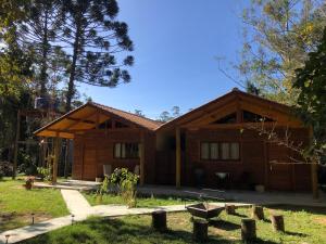 una casa con un árbol delante en Chalés Alcantilado - Morada Sol e Lua, en Visconde De Maua