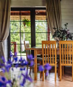 5 stories في Inkartai: غرفة طعام مع طاولة وكراسي وورود أرجوانية