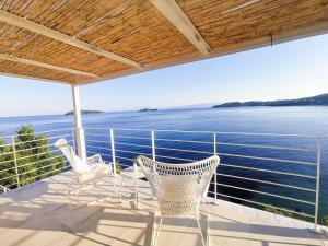 einen Balkon mit 2 Stühlen und Blick auf das Wasser in der Unterkunft Evgenia Seafront House in Skiathos-Stadt