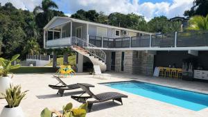 uma casa com uma varanda e uma piscina em Palm's Bohemian House with Private Pool em Aguada