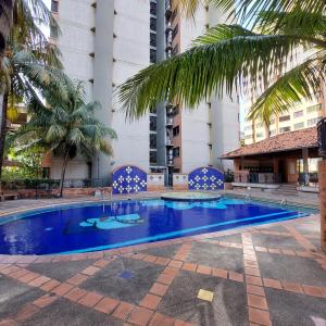 a large blue swimming pool in a courtyard with palm trees at Apartamentos Ejecutivos en Naguanagua in Naguanagua