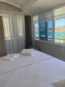een slaapkamer met een groot bed en uitzicht op de oceaan bij VENÜS PARK APART SUİTES in Çeşme
