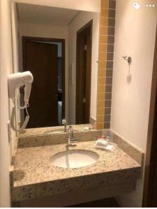 Un mostrador de baño con un lavabo y un espejo. en Apartamento de 6 pessoas Olimpia Park Resort, en Olímpia