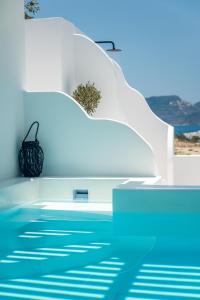 vistas a una piscina con un edificio blanco en Calma Suite Milos, en Adamas