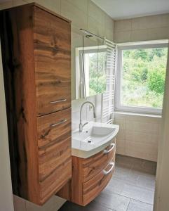uma casa de banho com um lavatório e um espelho em Panoramablick Exklusiv em Villach