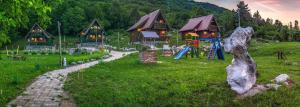 a playground in front of a house with a slide at Holiday Park Plitvice Paradise in Korenica