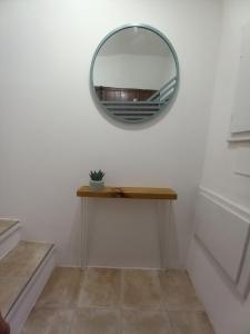 a mirror on a wall with a table and a shelf at Vicolo delle Forbici in Città della Pieve