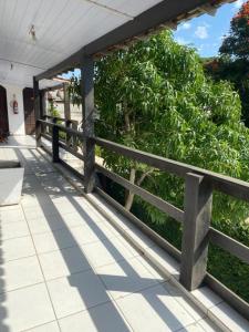 a porch with a wooden fence and a bush at Pousada Porto Búzios in Búzios