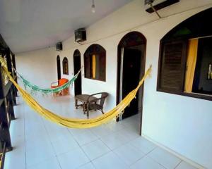 a hammock in a room with a table and chairs at Pousada Porto Búzios in Búzios