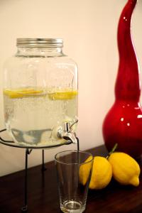 un frasco de agua con un vaso y limones sobre una mesa en DANLÚ en Salerno