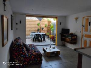 una sala de estar con un sofá y una mesa en Guest House Bien-être créole, en Sainte-Anne