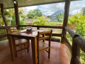 a table and chairs on a porch with a view at Arenal Homes La Fortuna in Fortuna