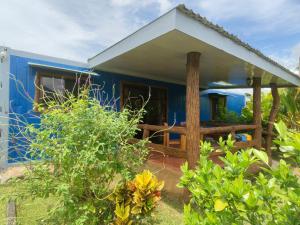 a blue house with a wooden fence in front of it at Arenal Homes La Fortuna in Fortuna