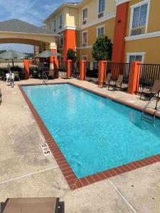a swimming pool in front of a apartment building at Best Western Plus - Magee Inn & Suites in Magee
