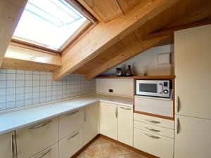 a kitchen with white cabinets and a skylight at Loft Mountain Spirit in Livigno +39 photos